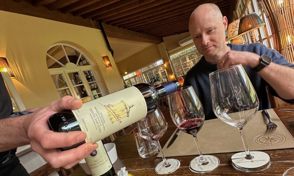 Guest tasting Tuscan wine during a winery visit, showing why driving after wine tastings in Tuscany requires careful planning.